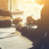 Businessperson Signing Contract about insurance, Two men writing with pen sign of modest agreements form In modern office, morning light, vintage color, success of business partners concept